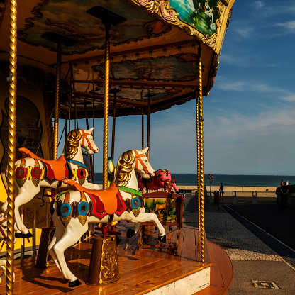 Adorable little girl on the playground. Toddler having fun on vintage carousel. Outdoor activities for small kids