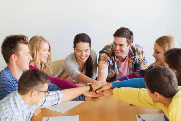 istock group of smiling students with hand on top 1307946908