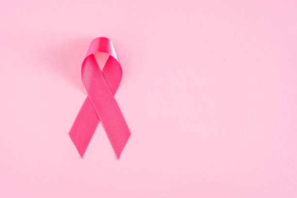 istock Pink ribbon on pastel background, top view 1307946973
