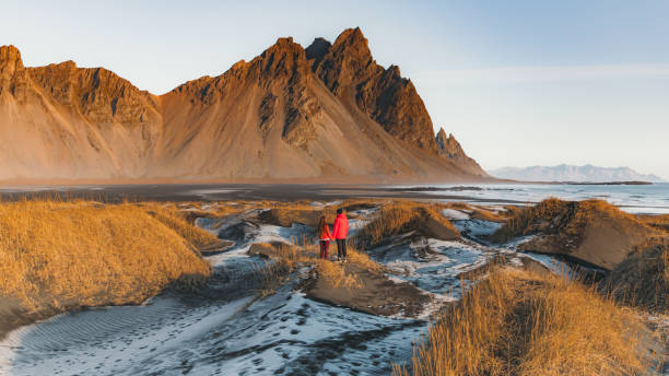 młoda para turystów odkrywających malowniczy krajobraz dzikiej przyrody na islandii podczas jasnego wschodu słońca na świeżym powietrzu - sunrise beach couple hiking zdjęcia i obrazy z banku zdjęć