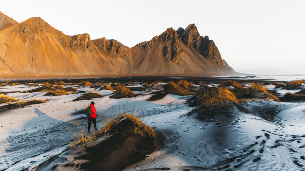 istock Man backpacker tourist exploring the scenic wilderness landscape in Iceland during bright sunrise outdoors 1307947963
