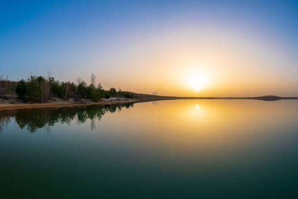 istock Beautiful sunset at a lake with a calm water surface 1307948523