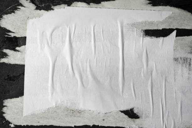 istock Scraps of white paper on a black plastered wall. 1307950483