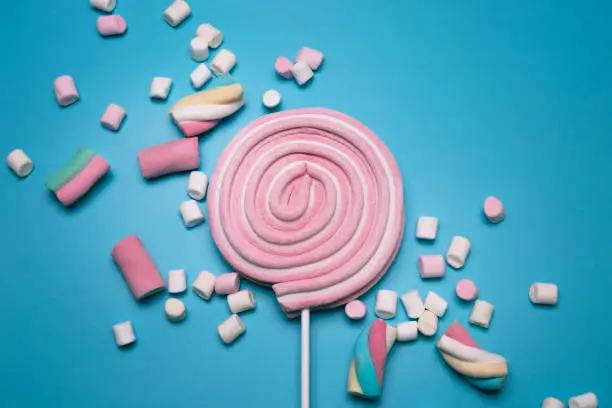 Photo of Marshmallows and lolly pop on the blue background.