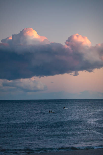 Small fishing boats fish at sunset on the Mediterranean Sea off the coast of Andalusia