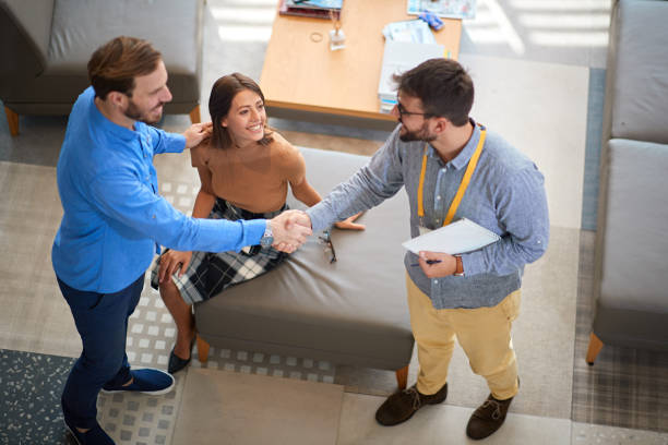 istock two young confident men shacking hands while handsome woman is watching. business, deal, concept 1307951785