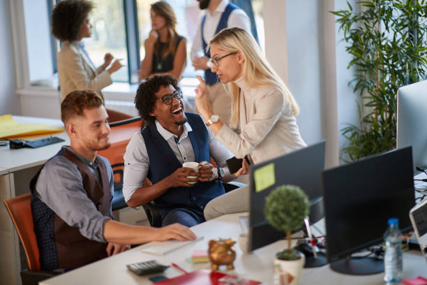 istock colleagues laughing at work in modern office. casual modern business 1307957159