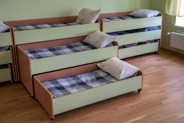 istock Many small beds in daycare preeschool empty bedroom. 1307957718