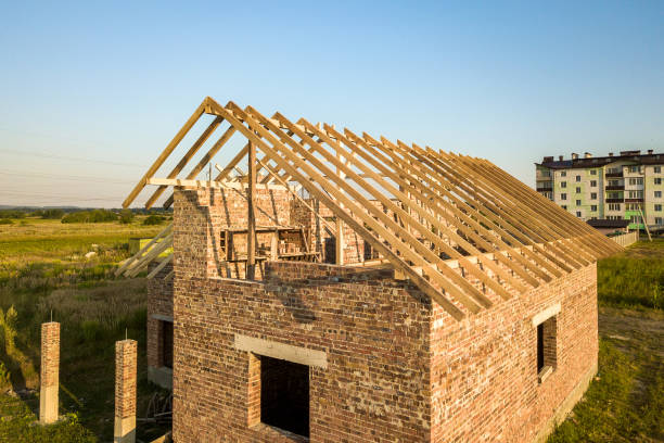 istock Unfinished brick house with wooden roof structure under construction. 1307957804