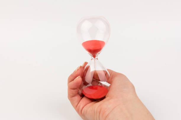 istock Hand holding a hourglass isolated on white background 1307957819
