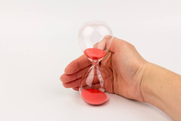 istock Hand holding a hourglass isolated on white background 1307957849