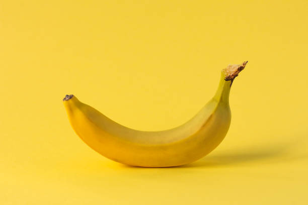 istock one yellow banana stands on a yellow background 1307960545