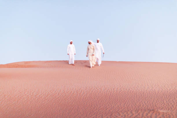 istock Arabs walking and exploring the dunes of Arabia 1307960601
