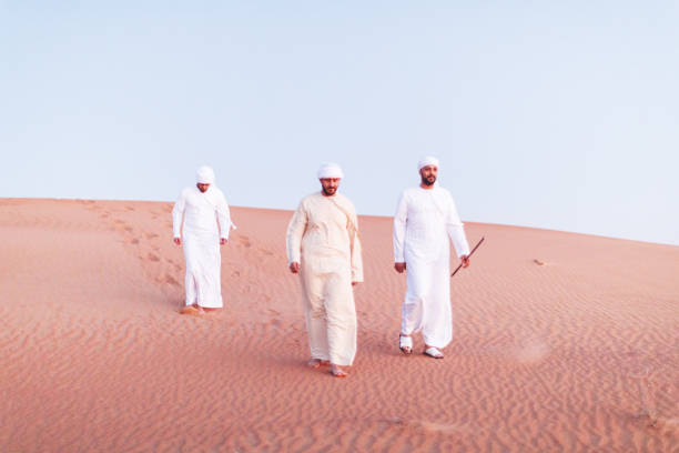 istock Arabs walking and exploring the dunes of Arabia 1307960642