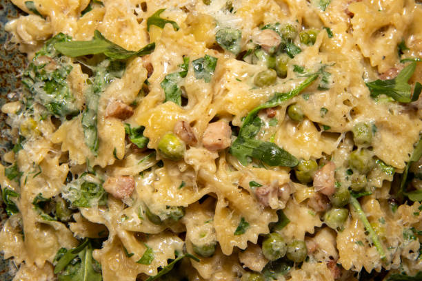 A delicious plate of Pancetta Parmesan and Pea Pasta A delicious plate of Pancetta Parmesan and Pea Pasta twisted bacon stock pictures, royalty-free photos & images