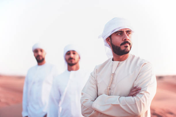 Group of Arab friends standing over sand dunes in style for a photograph