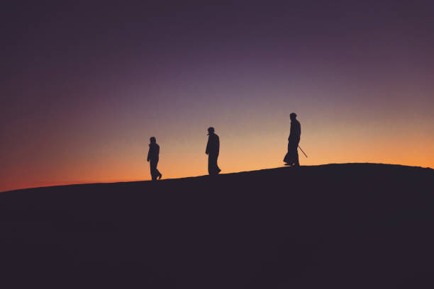 istock Arab men walking in line over sand dunes 1307962683