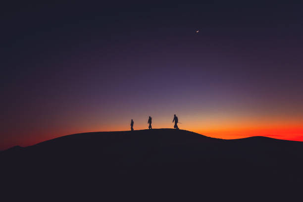 istock Arab men walking in line over sand dunes 1307962856