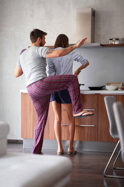 istock beautiful young couple having fun while making breakfast in modern kitchen. lifestyle, modern, young adults, casual, living concept 1307963897
