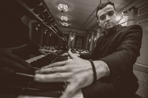 istock Male playing piano at concert hall 1307964187