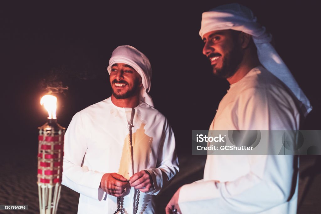 Arabs meeting at the desert camp Arab brothers meeting at a festive celebration at a desert camp site Ramadan Stock Photo