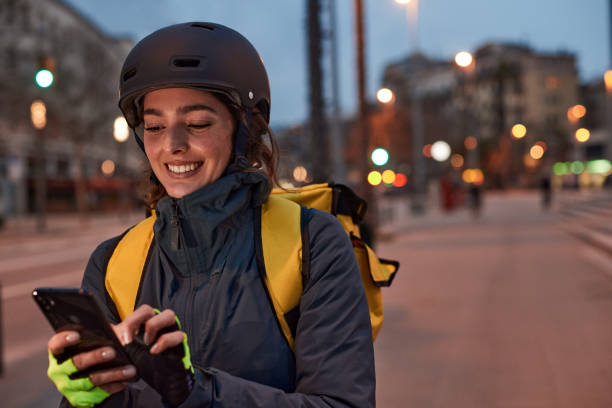 One delivery woman looking at her phone.