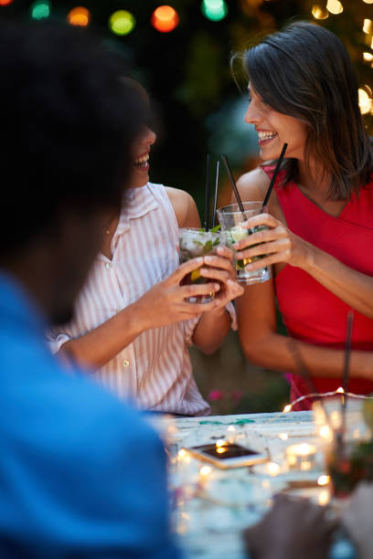 istock young adults making a toast, drinking cocktails, laughing. Fun, socializing, conversation concept 1307965417