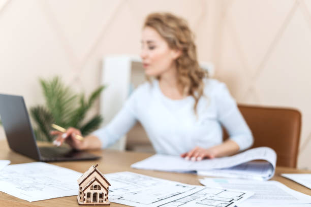 istock Woman sitting in office, working with blueprint 1307965549