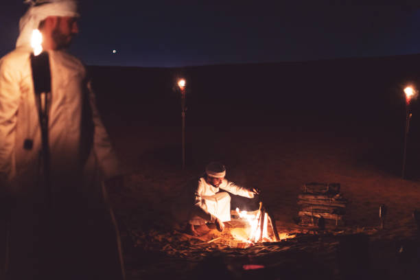 istock Arabs friends setting up campfire at a desert camp 1307965654