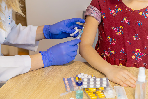 Injection vaccine against virus, injecting child.