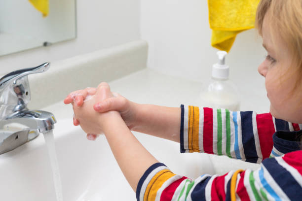 istock Child washing hands with soap in the bathroom 1307968677