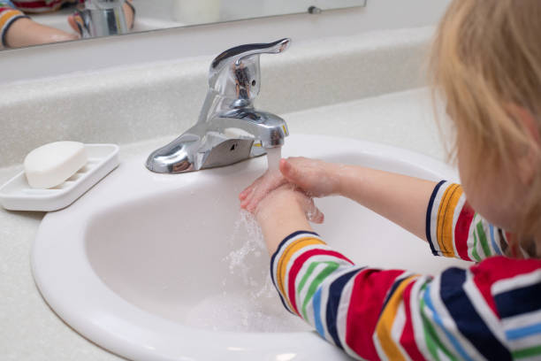 istock Child washing hands with soap in the bathroom 1307968680