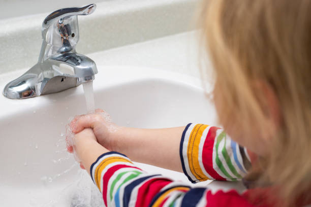 istock Child washing hands with soap in the bathroom 1307968682