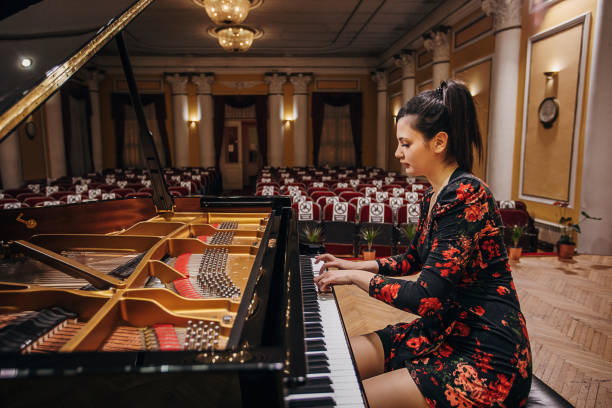 istock Female playing piano at concert hall 1307969316