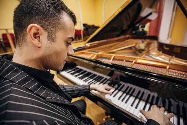 istock Male playing piano at concert hall 1307969589