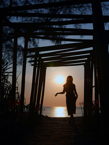 A sunset silhouette poses of woman at the beach