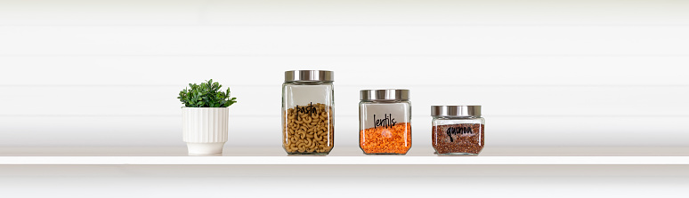Banner with glass food storage canisters on a white shelf
