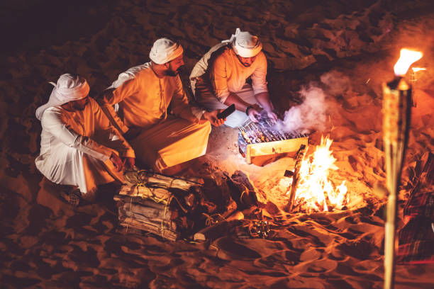 istock Arab friends at a desert camp grilling fresh kebab 1307975371