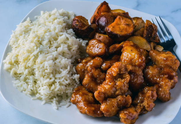 istock orange  chicken with white rice and potatoes 1307976468