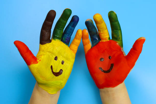 istock Children's hands painted with colorful bright colors on a blue background 1307978871