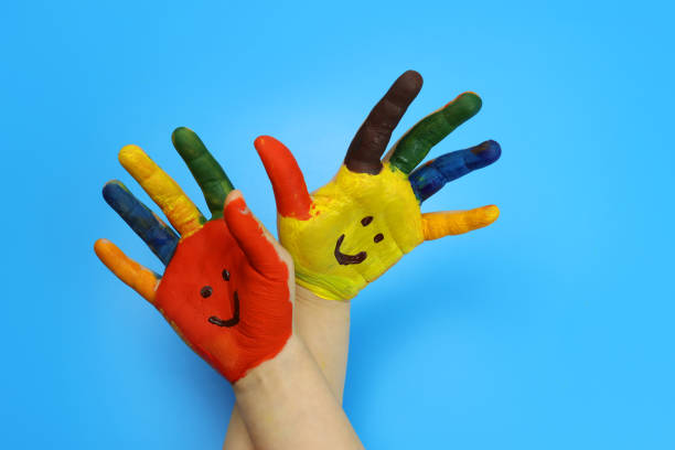 istock Children's hands painted with colorful bright colors on a blue background 1307978873