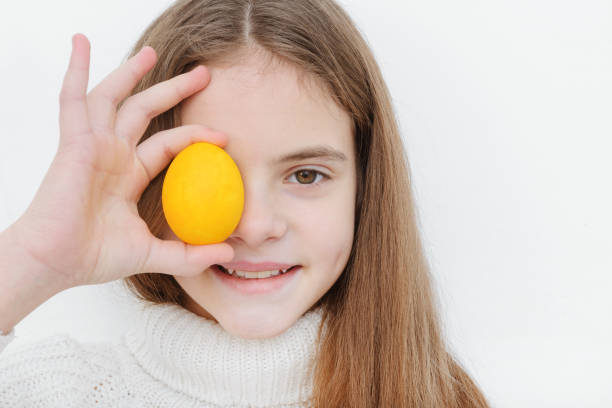 1 ragazza bianca carina di 10 anni con un uovo di pasqua giallo - 10 11 years cheerful happiness fun foto e immagini stock