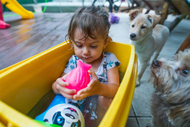 linda niña se enfría en un cubo de agua - 18 23 meses fotografías e imágenes de stock