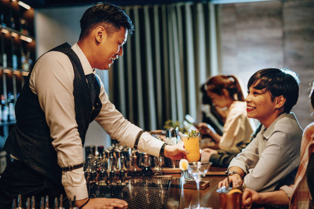 istock Polite cocktail master serving drink to ladies 1307980933