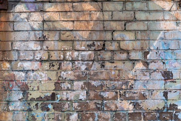 istock Cracked brick wall background with multiple layers of paint 1307981057