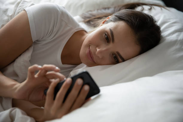 istock Teenage girl lying at bed using cellphone before fall asleep 1307981130