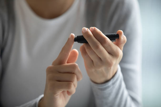 istock Young female diabetic patient holding portable glucometer checking blood sugar 1307981133