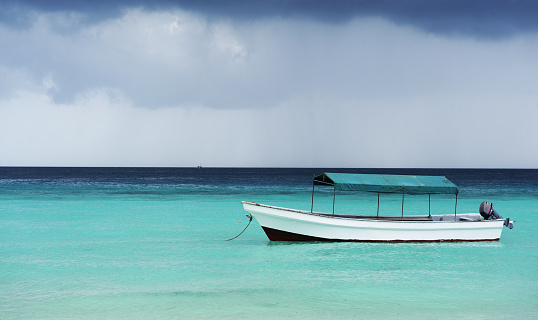 A fishing boat in the Indian Ocean against the backdrop of an approaching storm.ZANZIBAR - TANZANIA