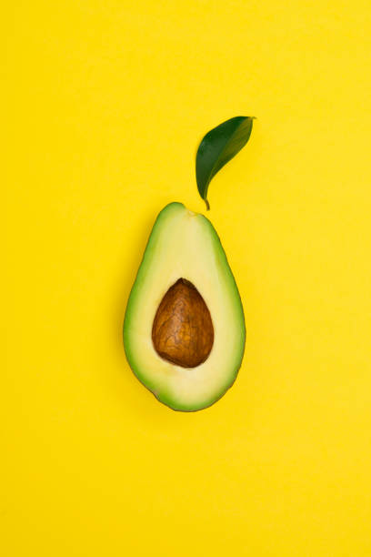 istock Ripe avocado on yellow background 1307985225