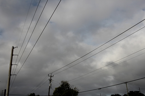 Power lines cables and a cloudy sky